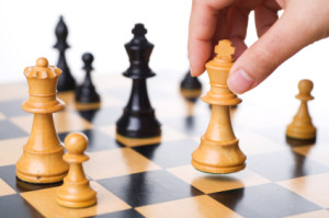 A hand moving the king in a chess game.